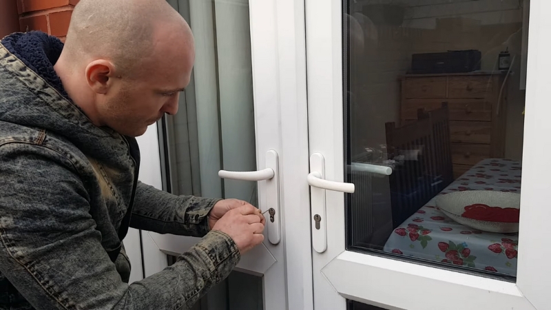 Muškarac pokušava da otključa zaglavljena PVC vrata pomoću alata