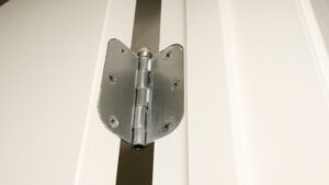 Metalna šarka pričvršćena na drvena vrata i štok